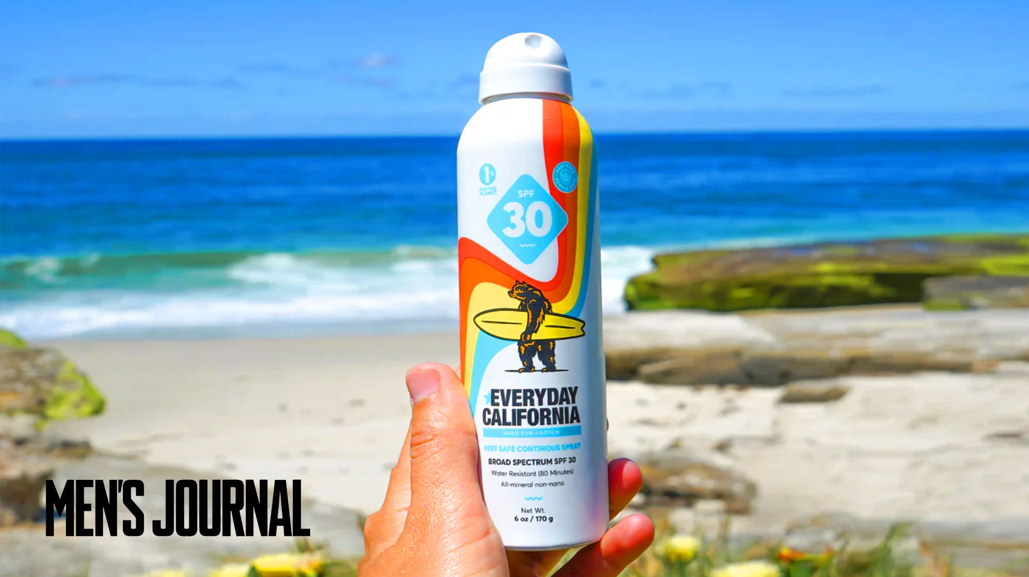 Everyday California SPF 30 spray sunscreen bottle being held by someone at the beach.